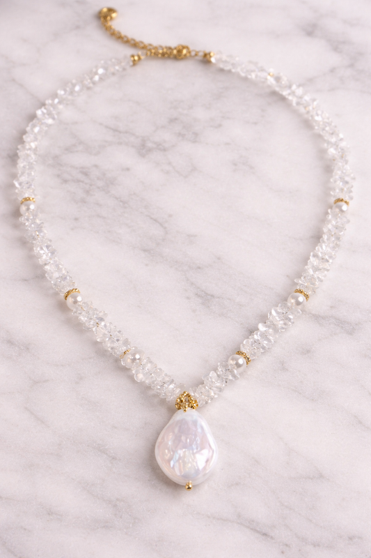 Necklace with a large pearl pendant on a marble background
