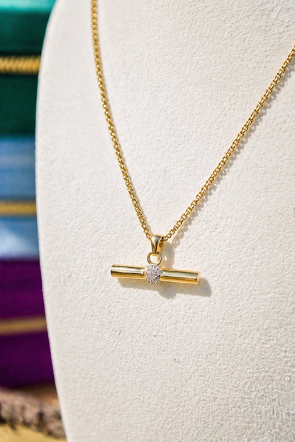 Gold necklace with a pendant on a white stand