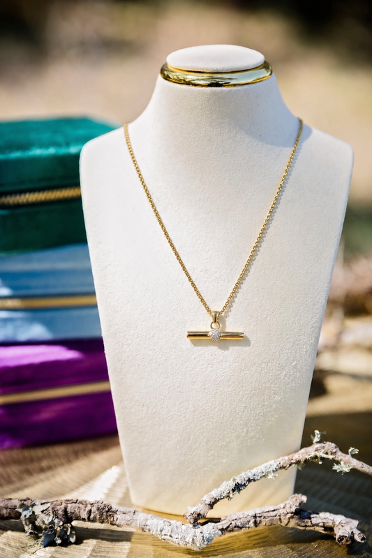 Gold necklace on a mannequin bust with a blurred background