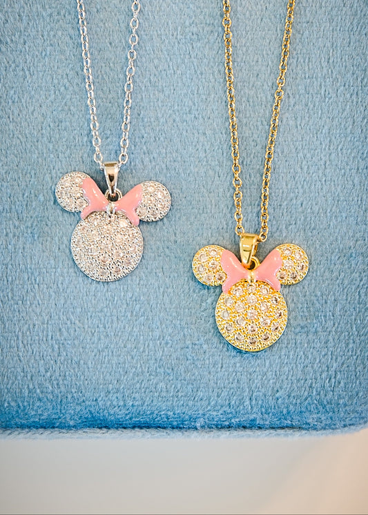 Close-up of pink enamel bow necklace in gold and silver options featuring pavé cz stones, dainty chain, and hand painted pink bow detail