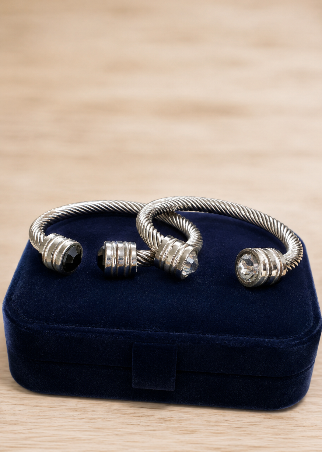 Silver bracelet on a blue velvet jewelry box with a wooden surface background