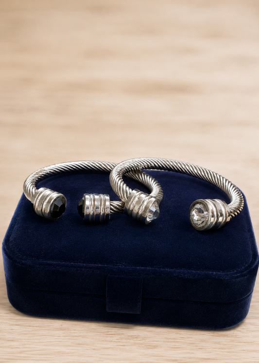 Silver bracelet on a blue velvet jewelry box with a wooden surface background