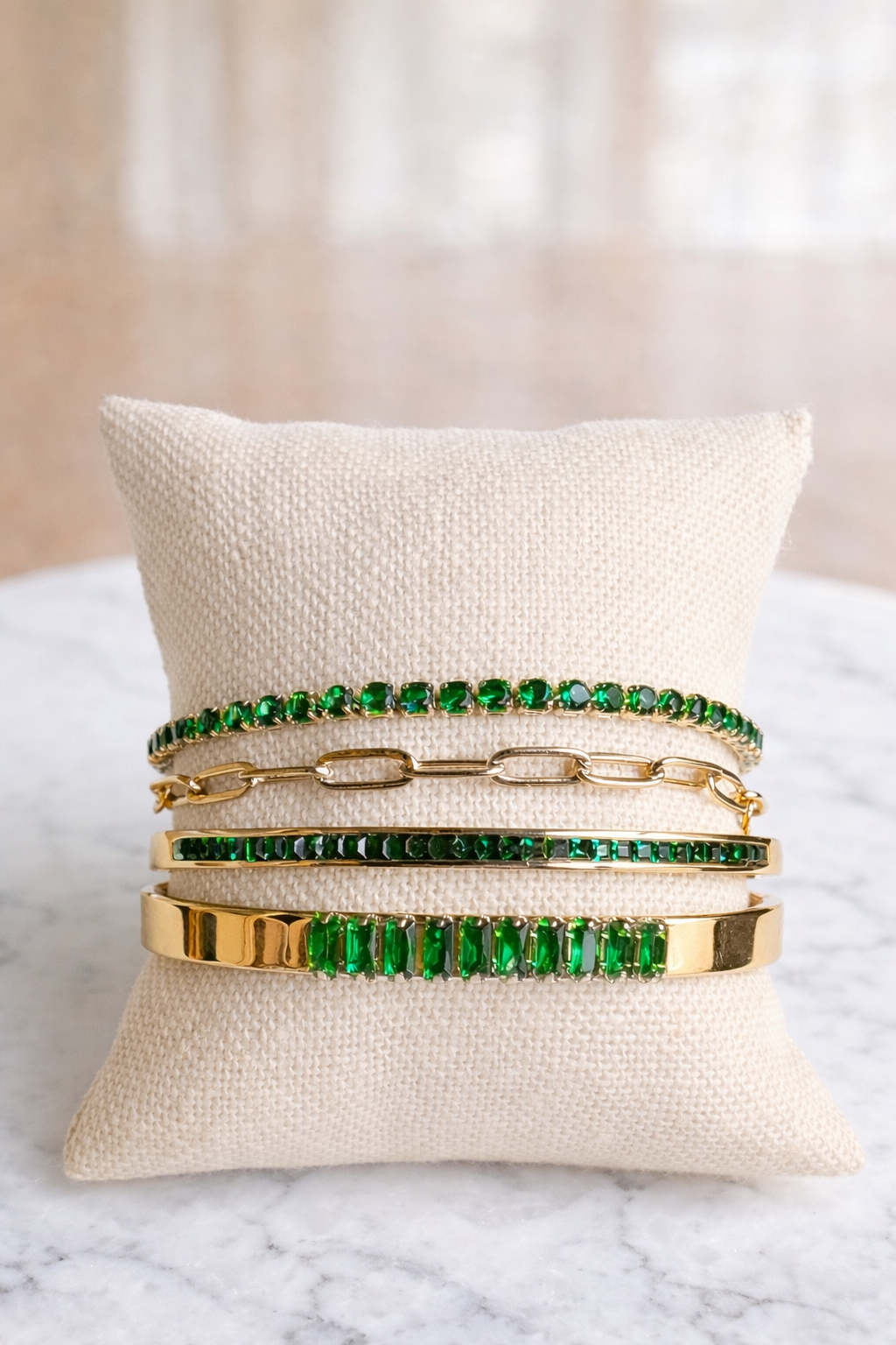 VEITA 4-piece gold bracelet stack with emerald green crystals layered on wrist