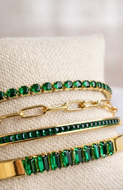 Close-up of VEITA gold bracelet stack with emerald green crystal tennis and bar bracelets
