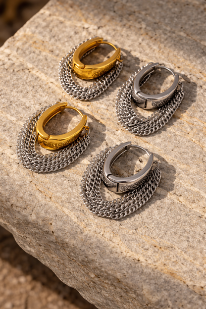 VEITA Jewelry chunky hoop earrings with cascading chain fringe shown in gold and silver options on stone surface