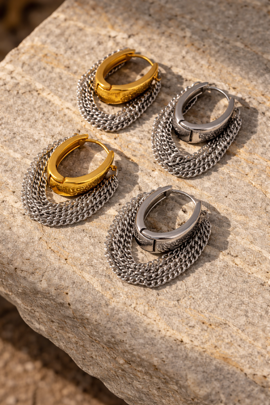 VEITA Jewelry chunky hoop earrings with cascading chain fringe shown in gold and silver options on stone surface