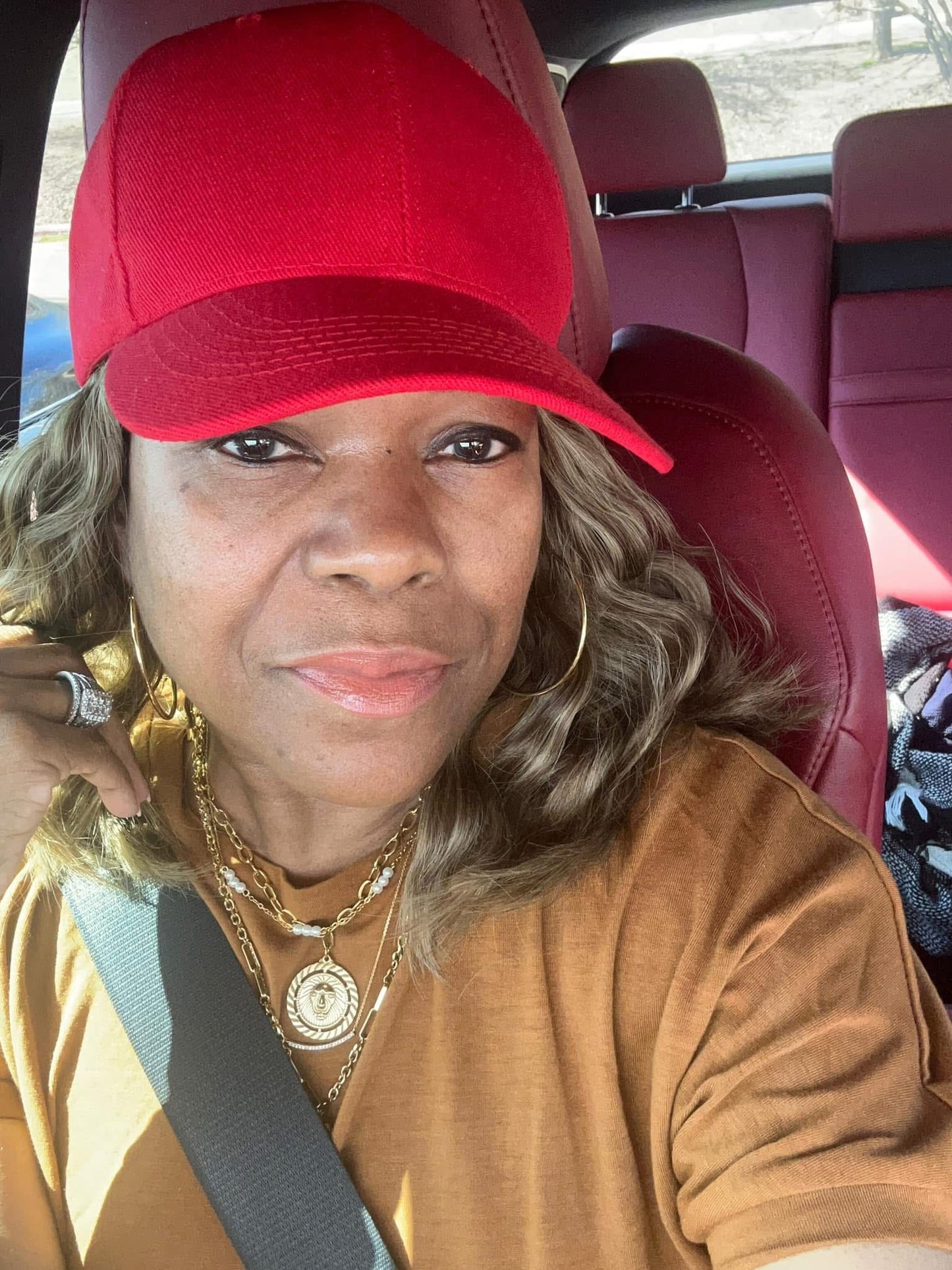 Model wearing VEITA Jewelry gold hoop earrings and layered gold necklaces with coin medallion pendant