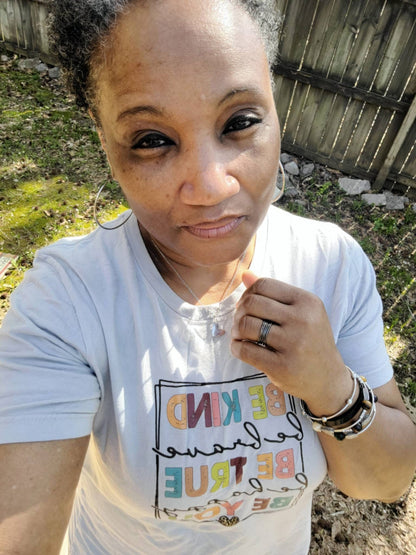 Model wearing VEITA Jewelry large gold hoop earrings, delicate chain necklace with charm, and stacked bracelets
