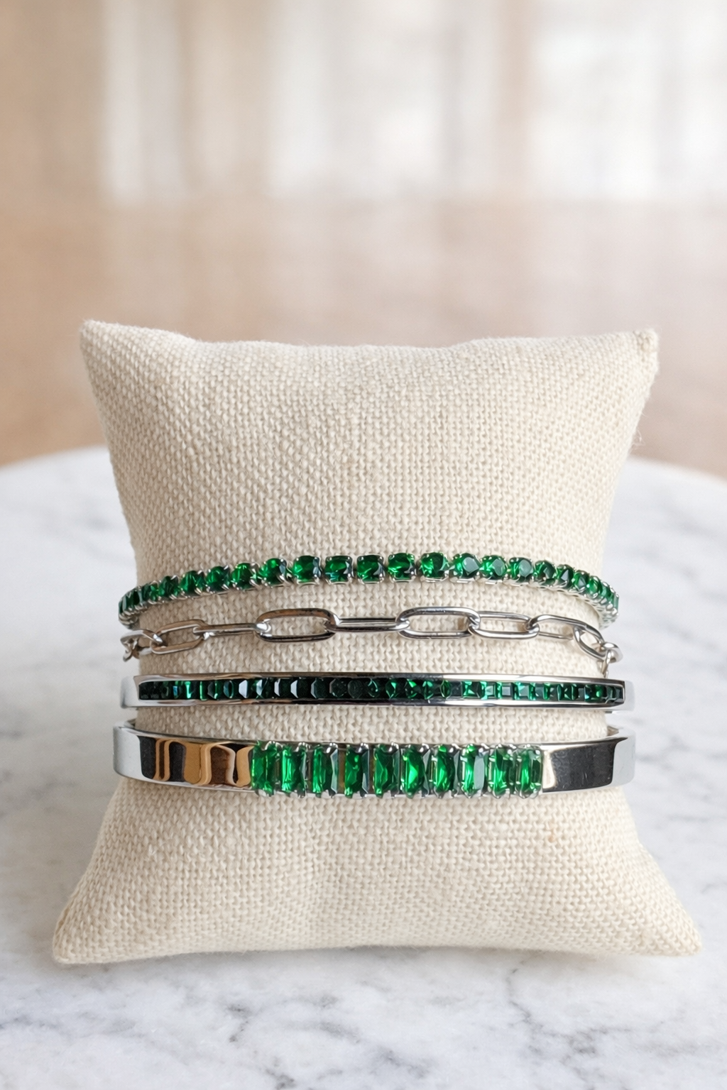 VEITA silver and emerald green crystal bracelet stack styled together on pillow