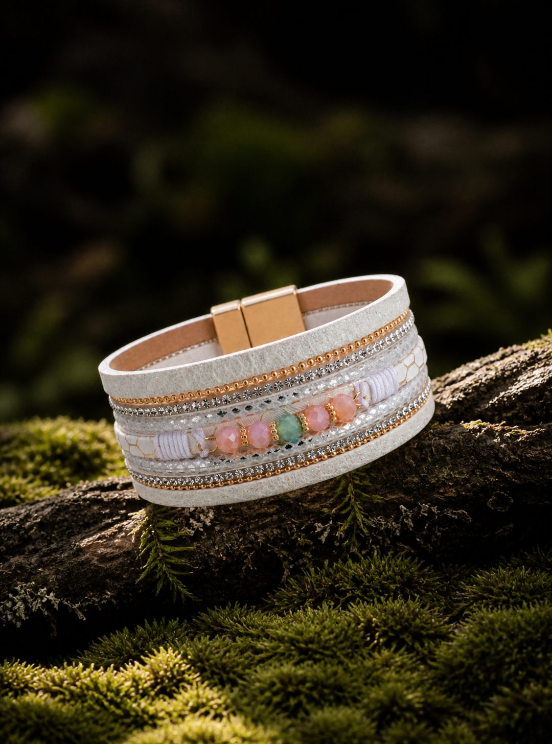 Multistrand bracelet with beads on a wooden branch with moss